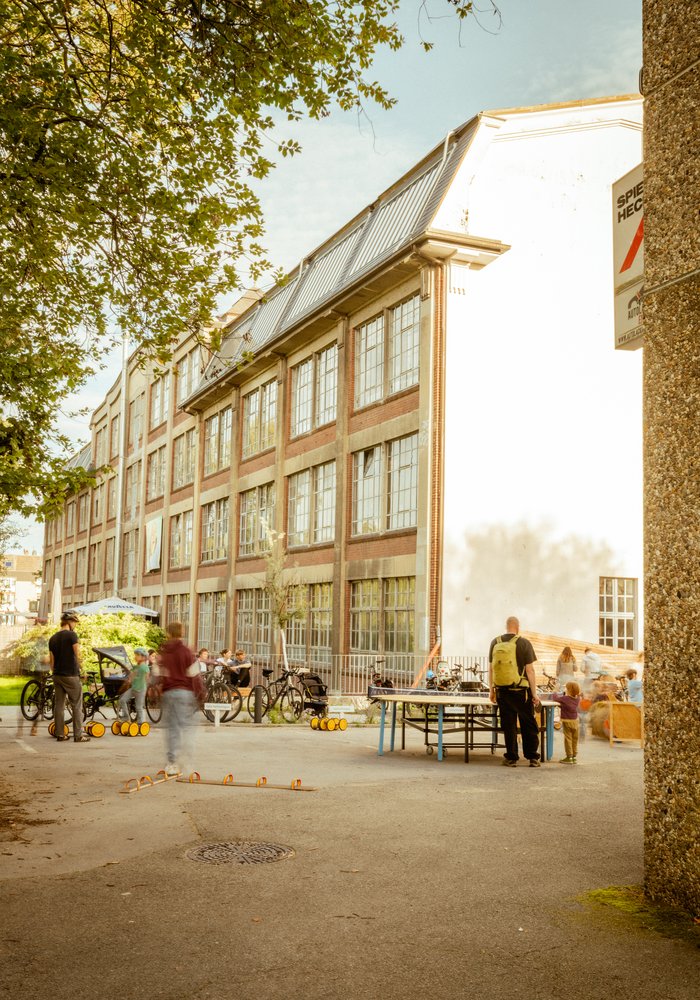 Die Wiesenwerke mit den großen Fenstern und Menschen und Kindern, die spielen