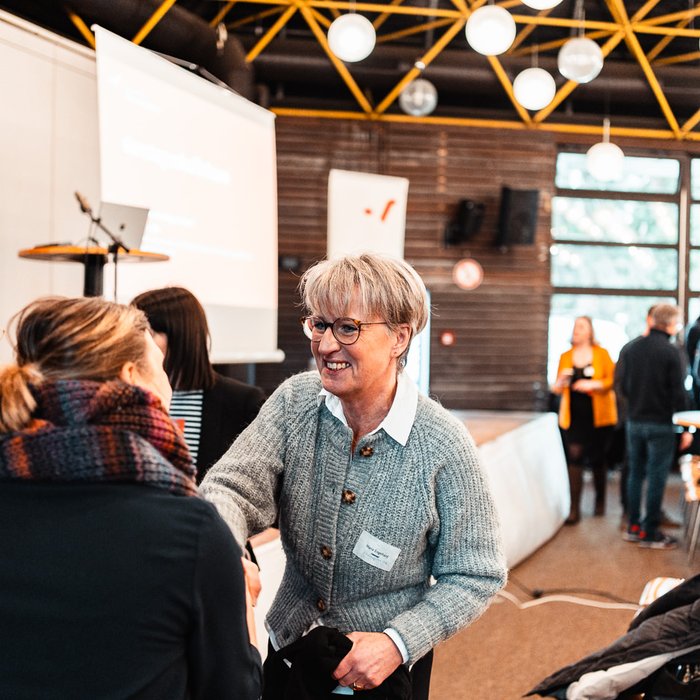 Netzwerktreffen Ganztag und Raum der Montag Stiftung Jugend und Gesellschaft: Ein Frau reicht zu einer anderen Frau herüber, um ihr die Hand zu reichen