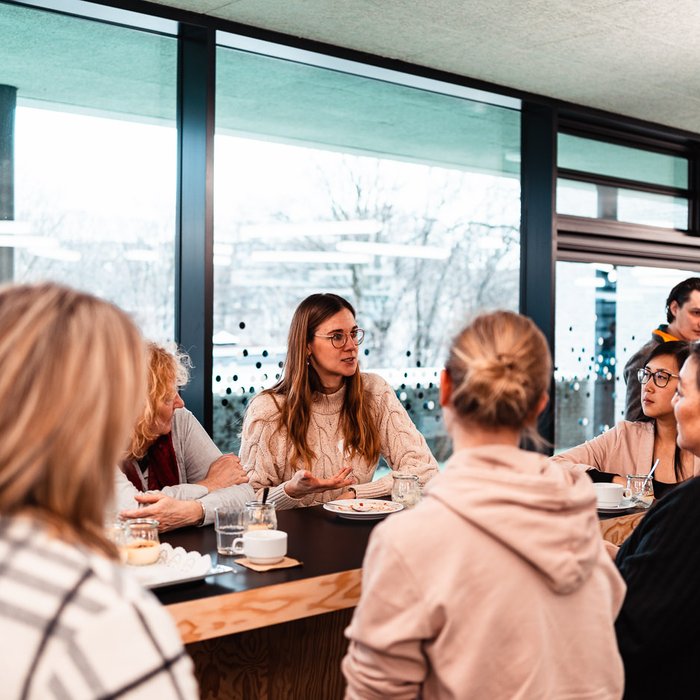 Netzwerktreffen Ganztag und Raum der Montag Stiftung Jugend und Gesellschaft: Eine Gruppe mehrheitlich junger Frauen am Tisch im Gespräch