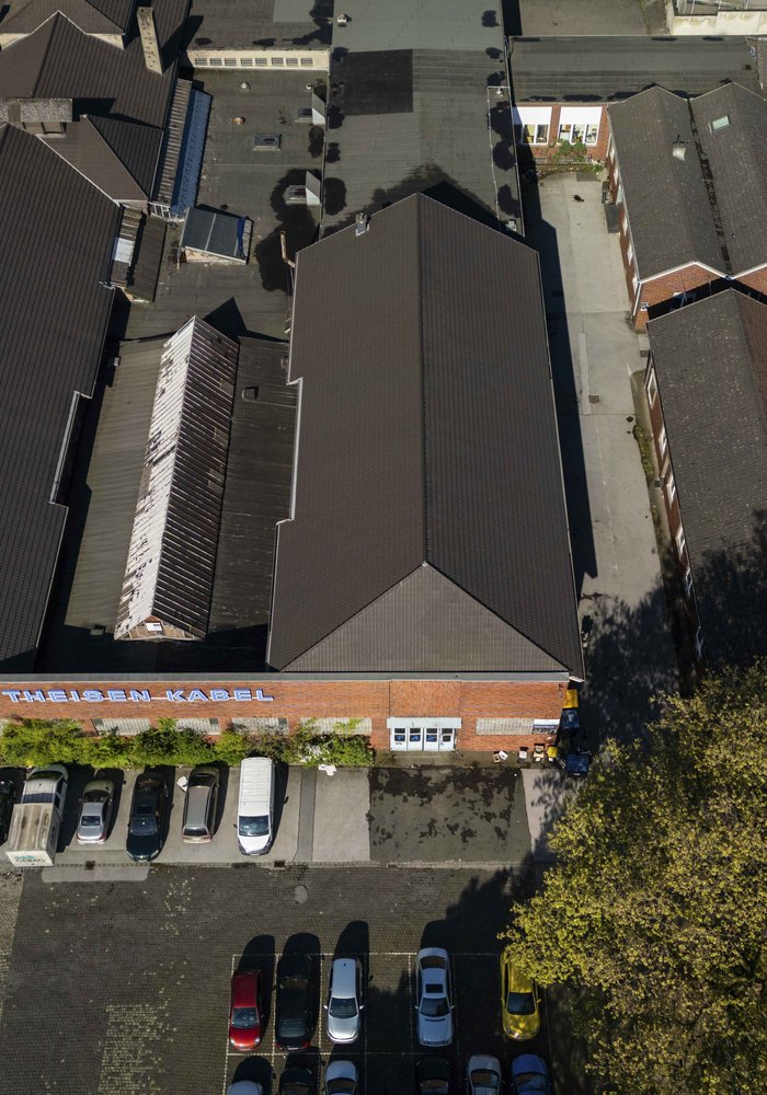 Die Gebäude der Musfeldstrasse 120 von oben. Zwei lange Industriehallen, die in der Mitte verbunden sind.