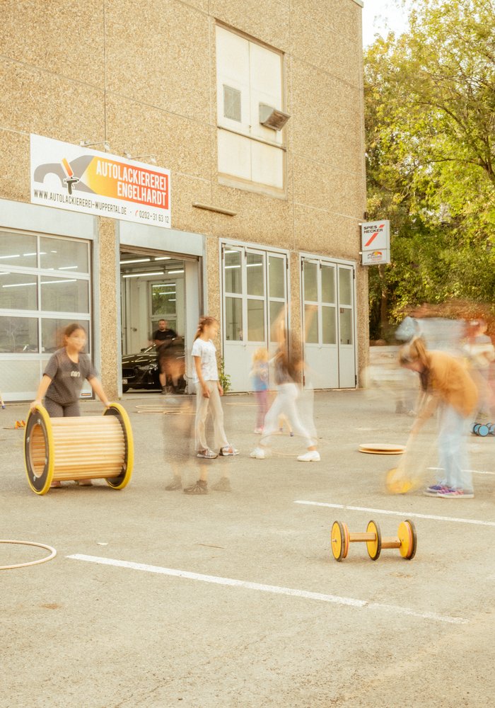 Ein paar Kinder spielen mit Pedalos und Rollen